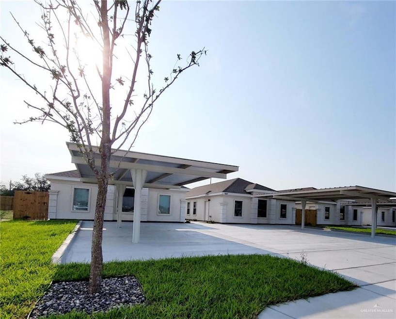 View of front facade with fence, a front yard, stucco siding, and driveway