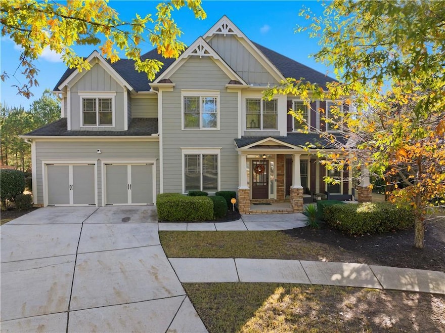 Craftsman-style house featuring board and batten siding, concrete driveway, an attached garage, a shingled roof, and covered porch