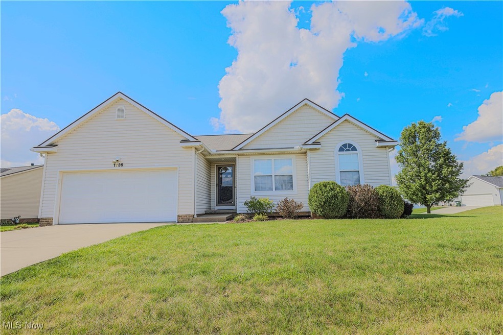 Ranch-style home featuring a front yard and a garage