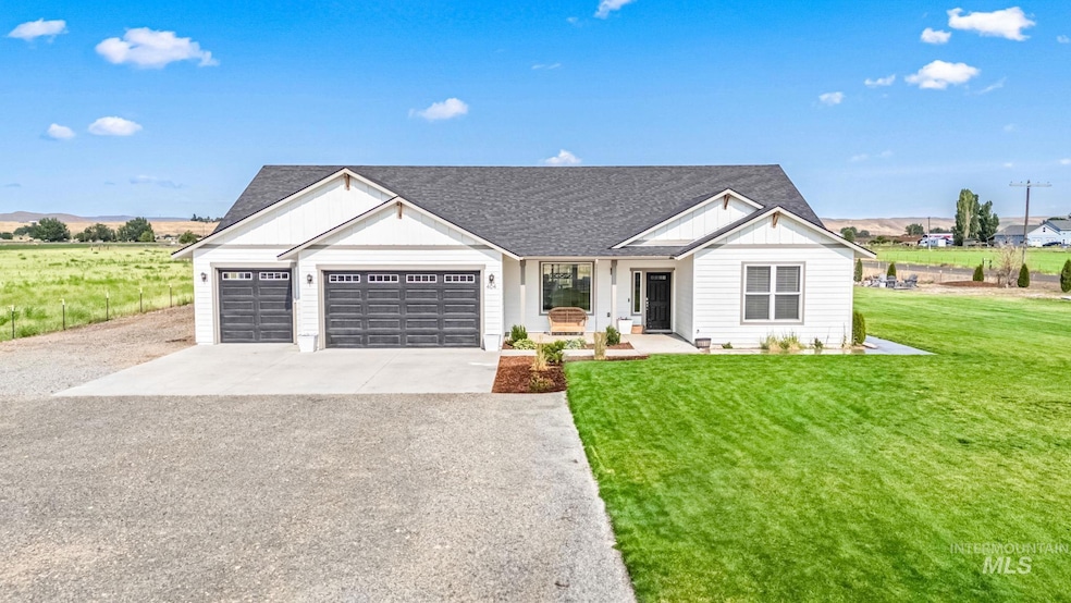 Modern farmhouse style home with driveway, an attached garage, a front yard, and a shingled roof