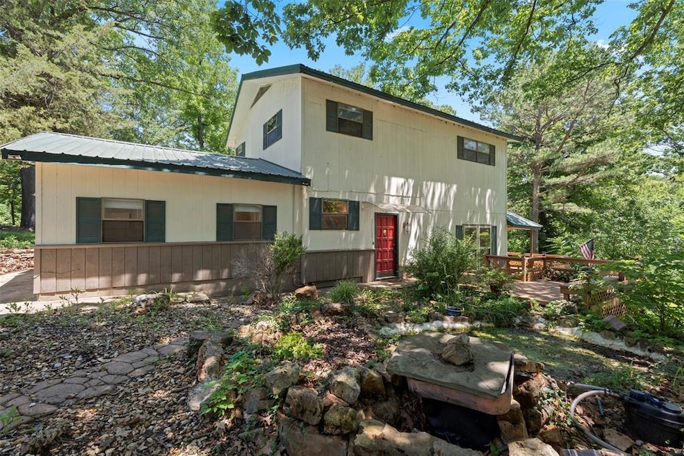 View of front of house featuring a wooden deck and a metal roof