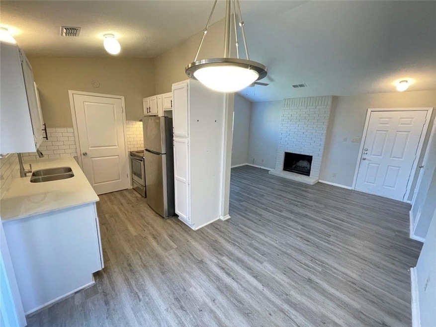 Kitchen featuring visible vents, a sink, white ca