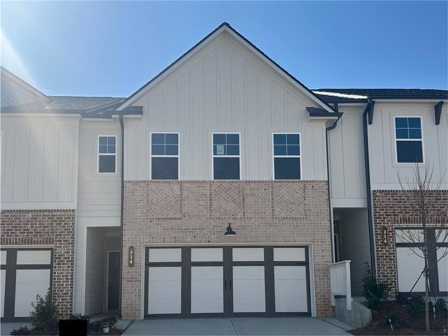 View of property with driveway, brick siding, boar