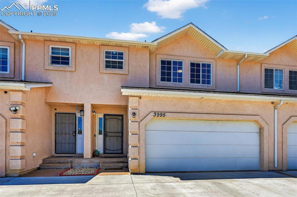 Townhome / multi-family property featuring stucco siding, an attached garage, and driveway