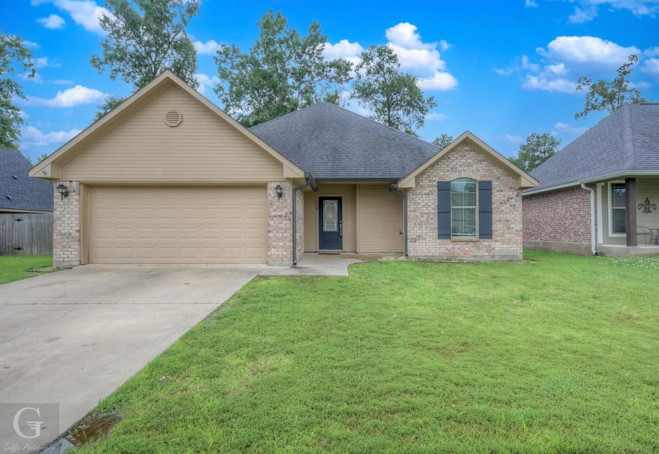 Ranch-style house featuring a garage and a front y