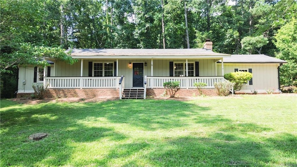 Ranch-style home featuring a chimney, covered porch, and a front lawn
