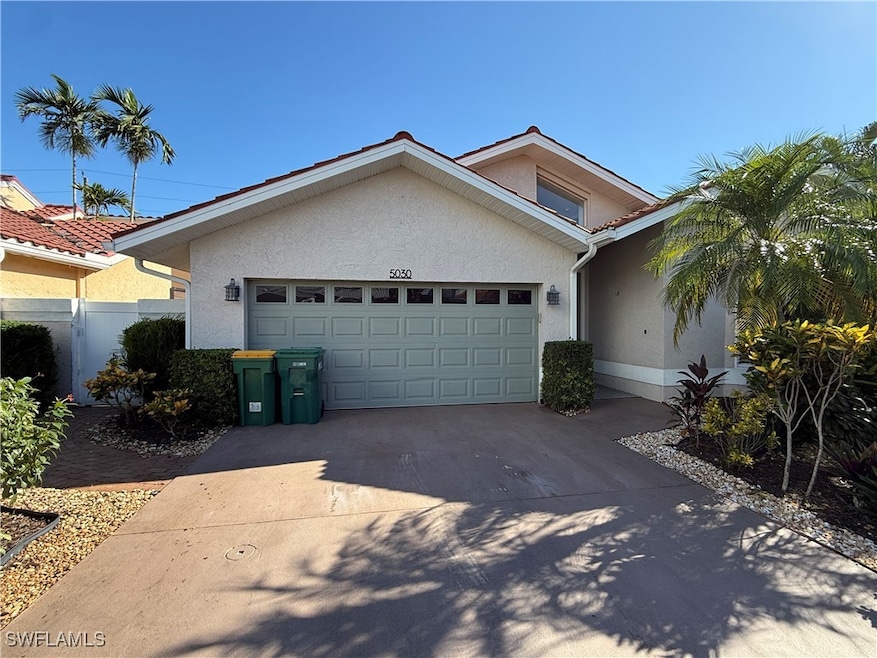 View of front of home with stucco siding, concrete driveway, and an attached garage