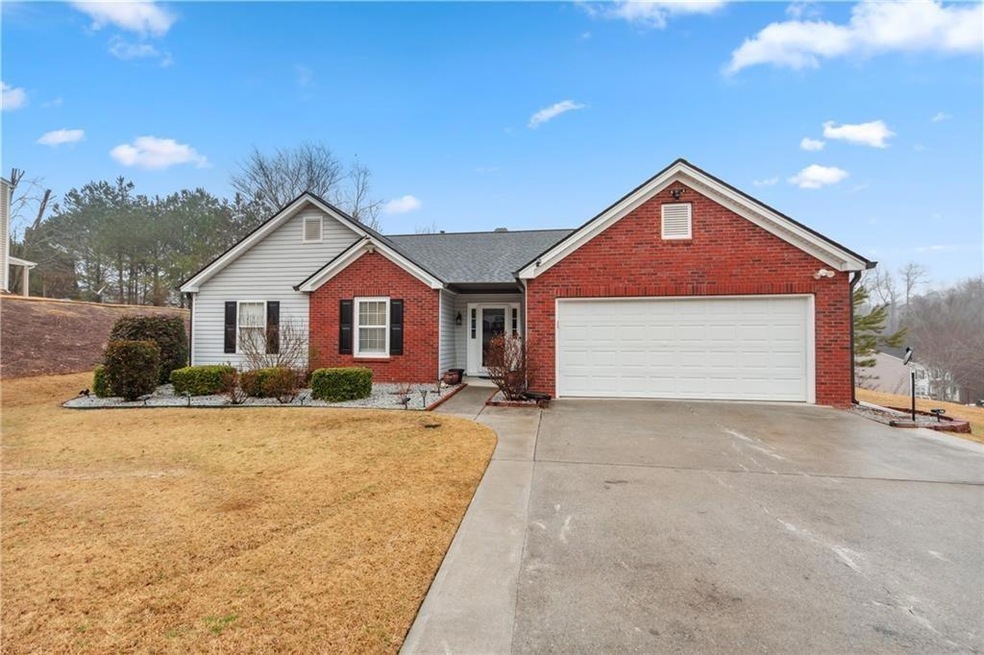 Single story home featuring concrete driveway, a g