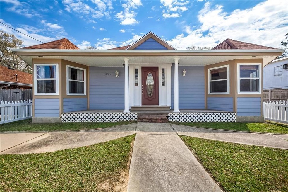 Front of home is enclosed by a white picket fence