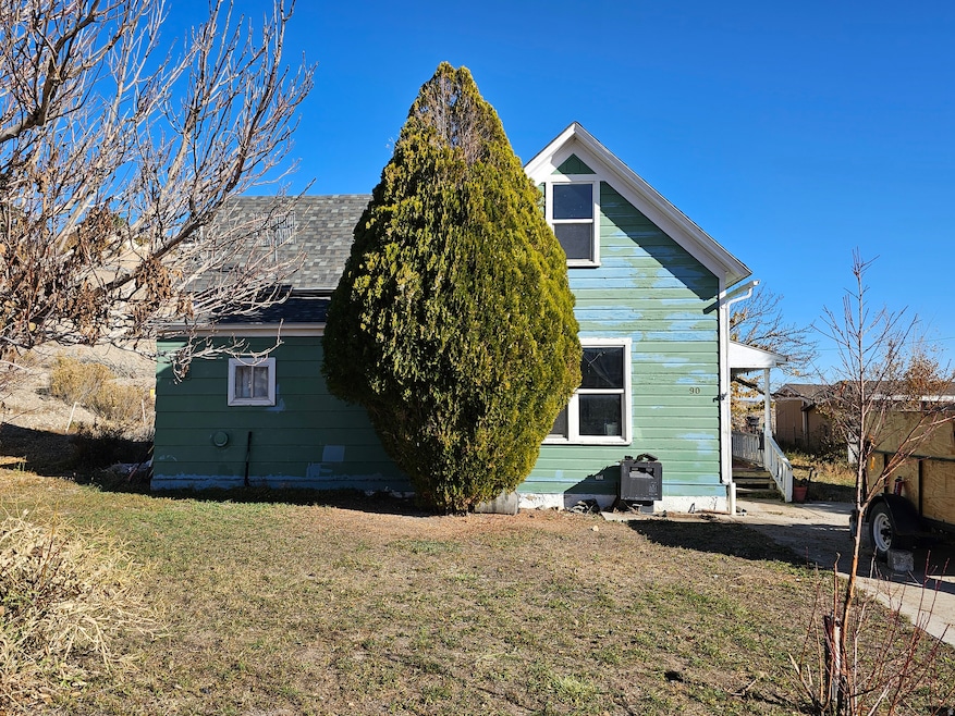 Back of property with a yard and roof with shingles