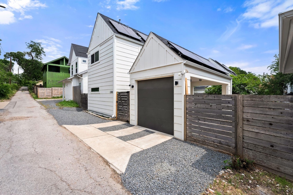View of side of home with driveway, board and bat