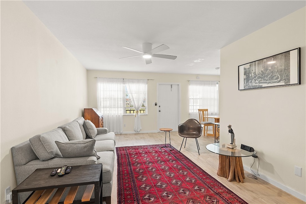 Living room featuring light wood-style flooring and a ceiling fan