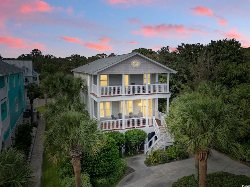 Raised beach house with a porch, a balcony, and stairway