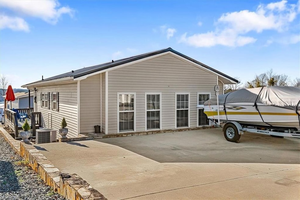Welcome home to lake living at 102 Scenic View Way! Outdoor view of the home features the driveway with ample parking spaces.