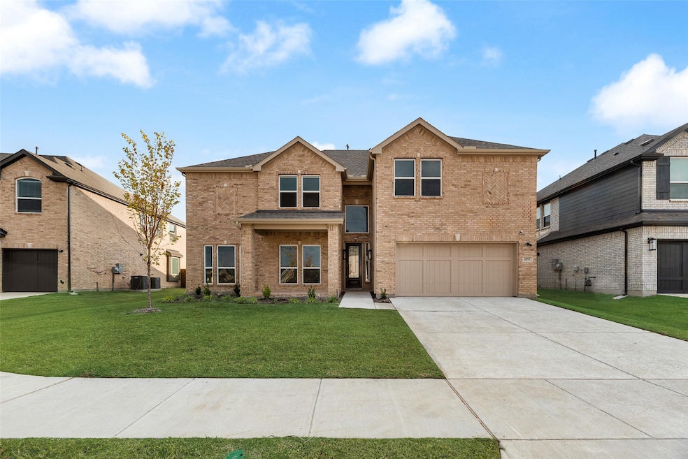 Traditional home featuring brick siding, a front yard, concrete driveway, and an attached garage