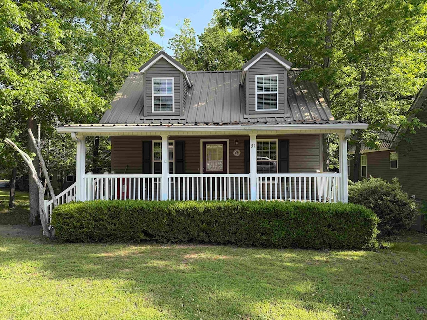 Cape cod home with a porch, metal roof, and a fron