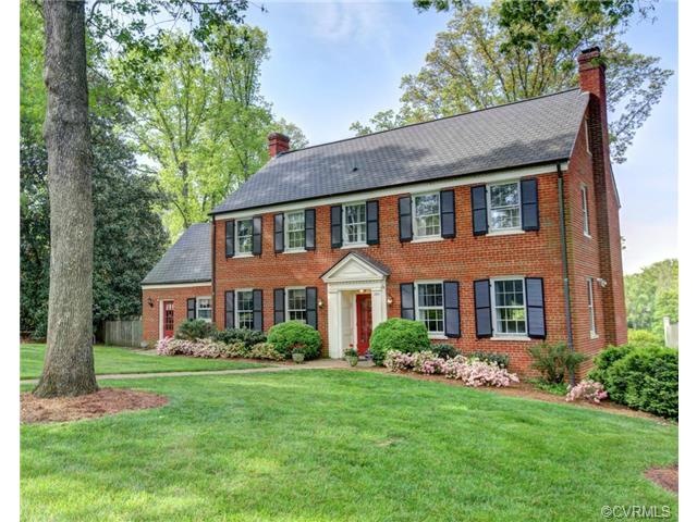 A classic all-brick Colonial with mature landscapi