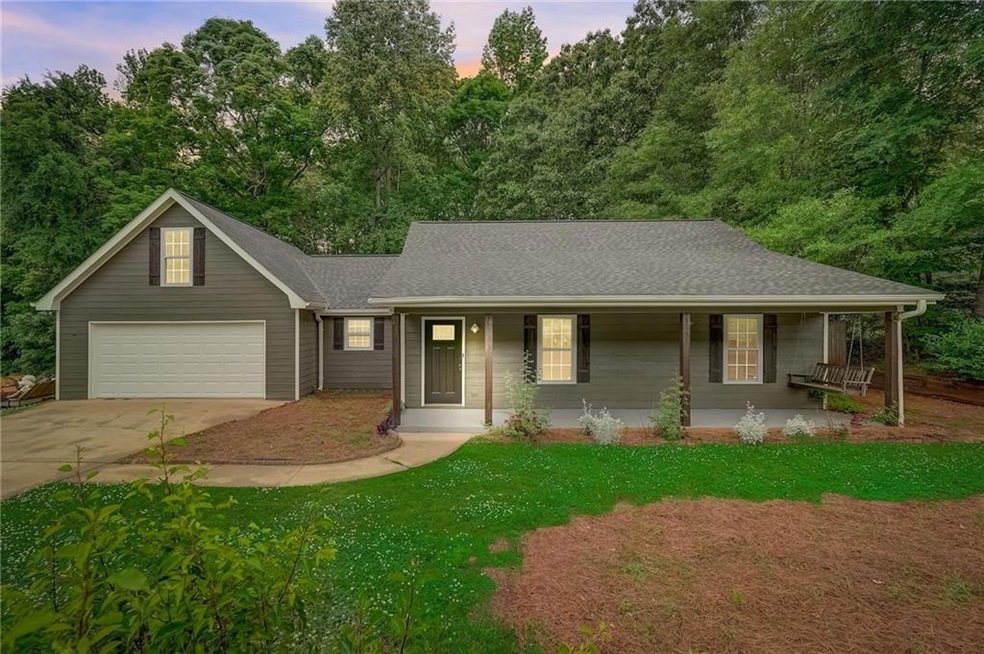 View of front of house with covered porch and a ga