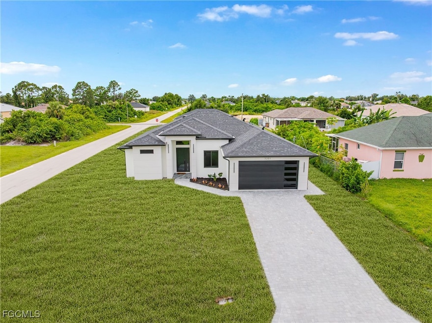 View of front facade with a residential view, decorative driveway, a garage, stucco siding, and a front yard