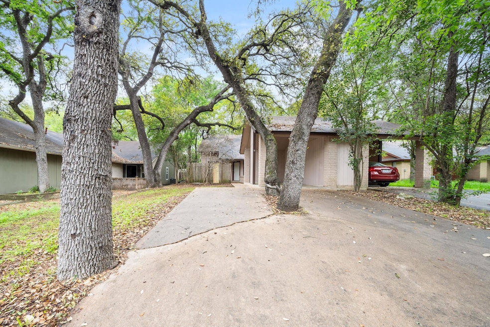 Mid-century home with brick siding, driveway, and