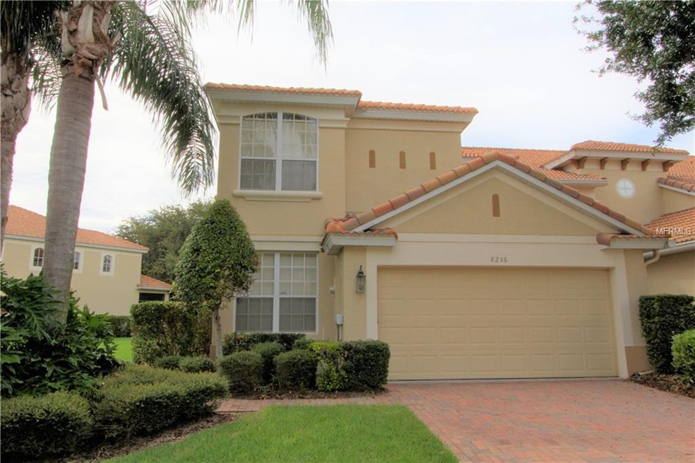 End-unit townhome featuring tile roof, paver drive