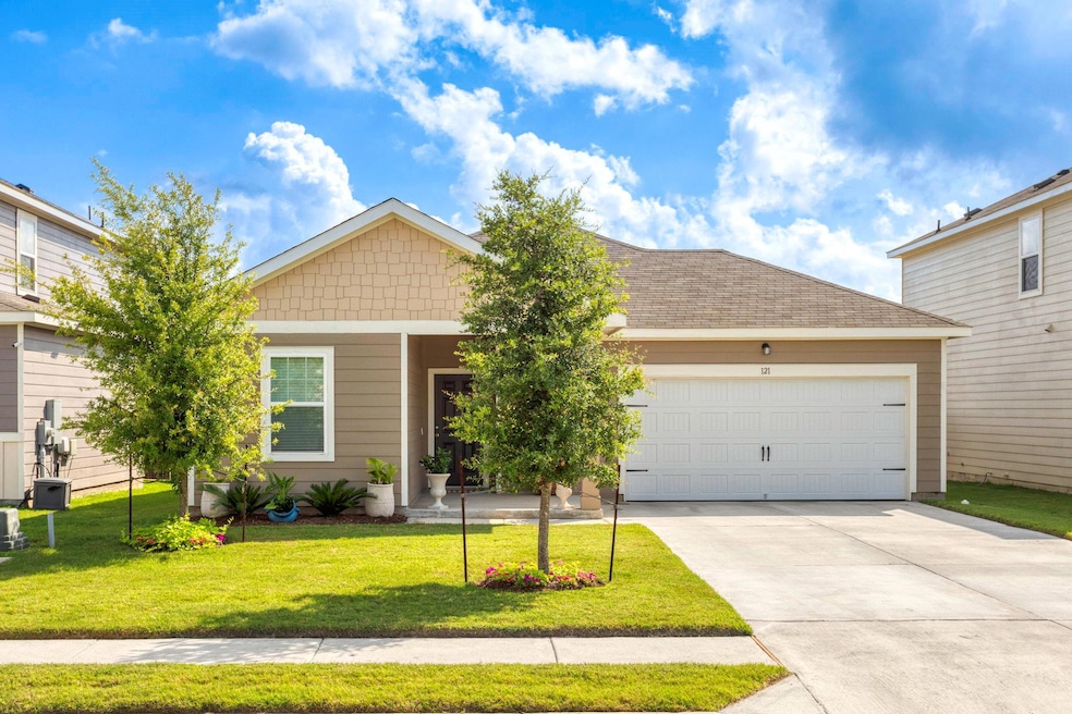 View of front of property featuring driveway, an attached garage, a front lawn, and a shingled roof
