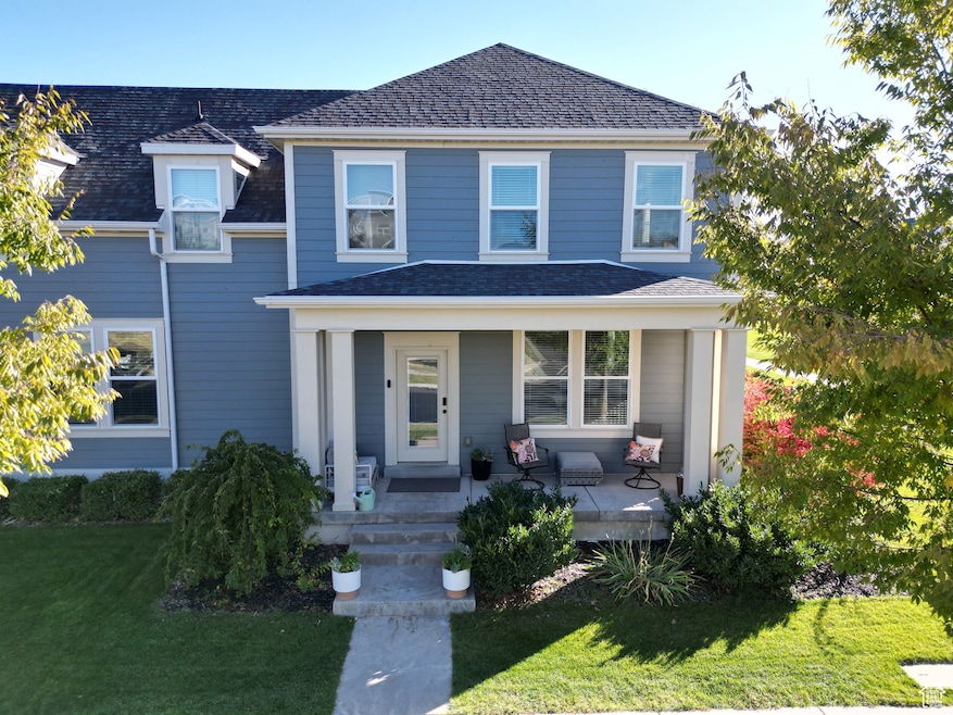 View of front of home with a porch, a front yard, and roof with shingles