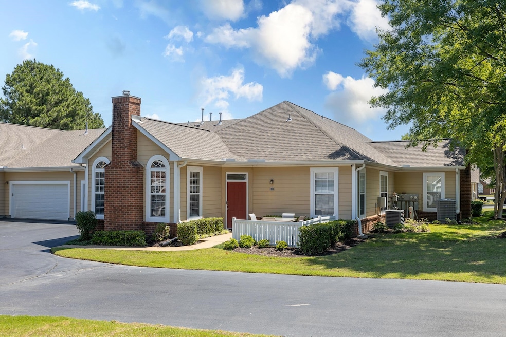 Ranch-style home featuring a garage, central air condition unit, a front yard, a chimney, and driveway