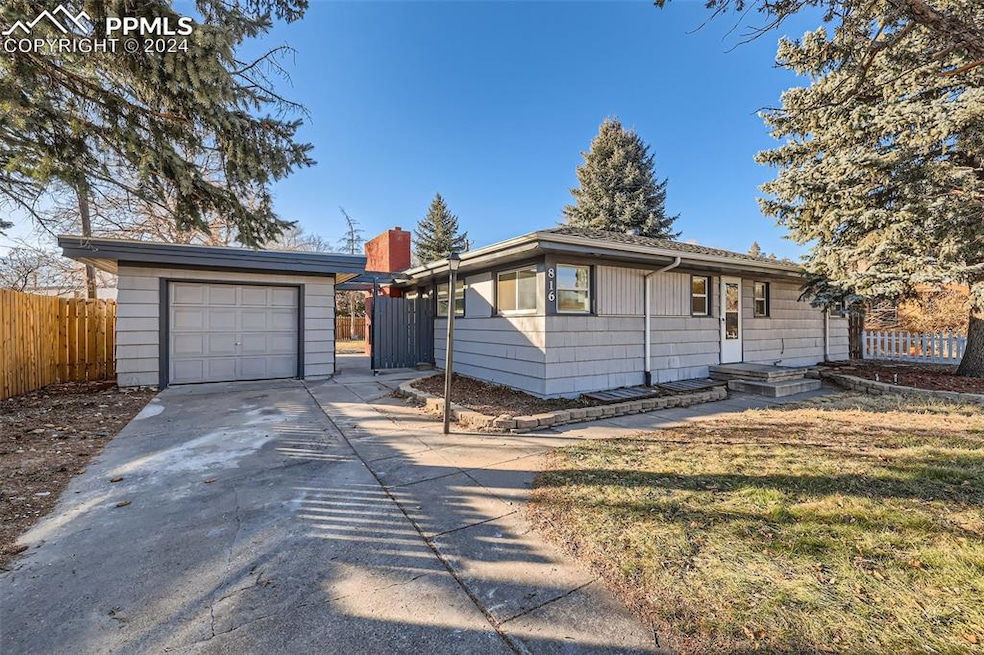 Ranch-style house featuring a front yard and a gar