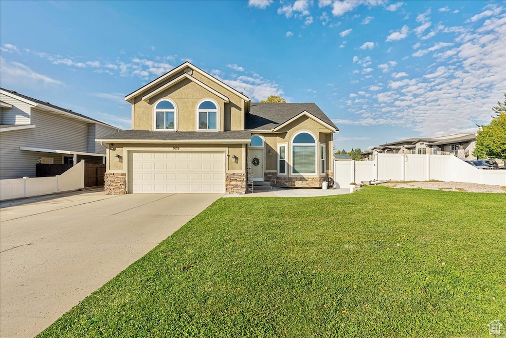 View of front of house featuring stucco siding, concrete driveway, stone siding, and an attached garage