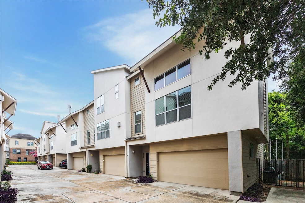 Modern townhouse with a three-story design, featuring large windows and a two-car garage. The corner unit allows for seamless accessibility. 