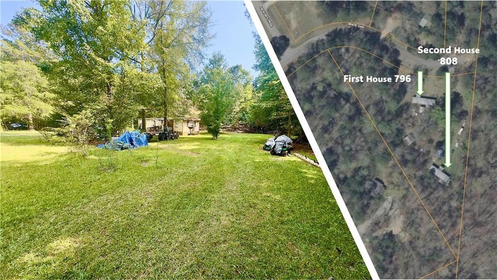 View of grassy yard with view of wooded area