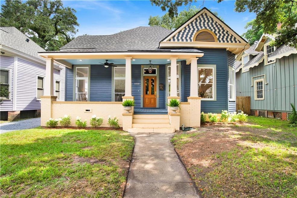 View of front facade with covered porch, a ceiling fan, a front yard, and roof with shingles