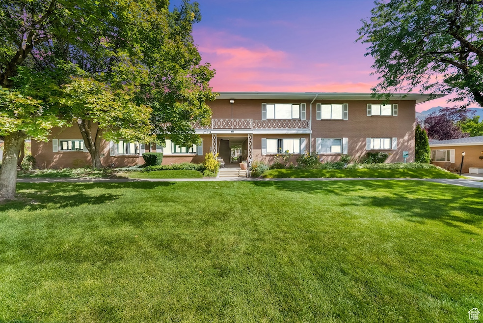 View of front facade with a lawn and brick siding