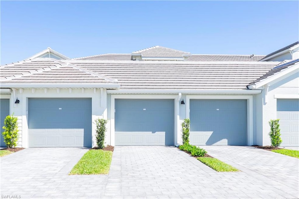 View of property featuring a tiled roof and stucco siding