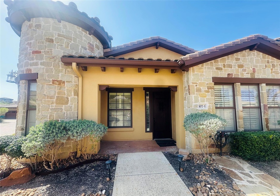 Doorway to property with stone siding, stucco sid