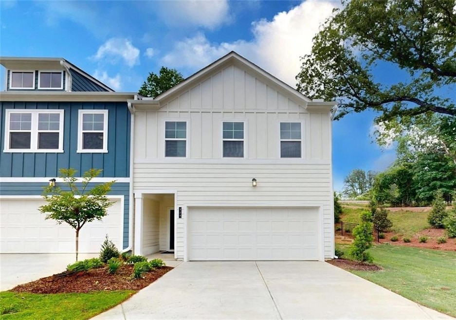 View of front of property with board and batten siding, a garage, and driveway