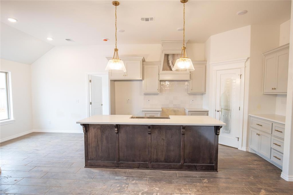 Kitchen featuring hanging light fixtures, backspla