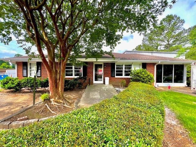 Single story home featuring brick siding and a front lawn