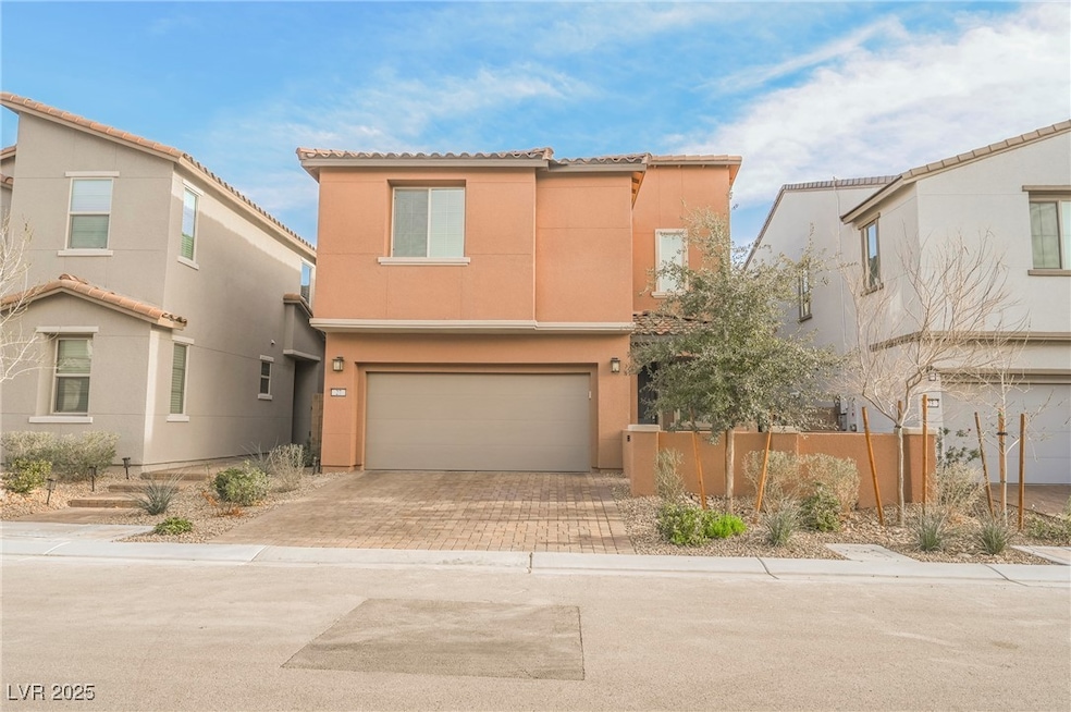 Mediterranean / spanish home featuring stucco siding, a garage, and decorative driveway