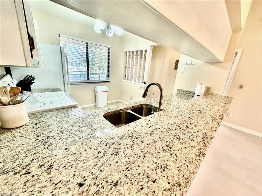 Kitchen featuring light stone counters, sink, kitc