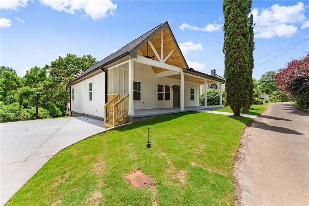 Modern farmhouse featuring board and batten siding, a front lawn, and driveway