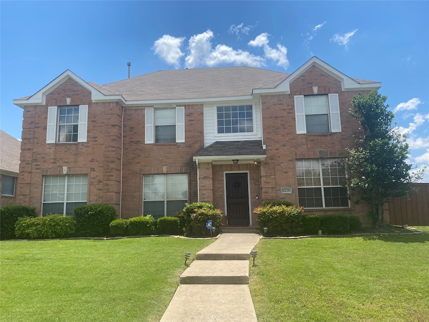 Traditional home featuring brick siding and a shingled roof