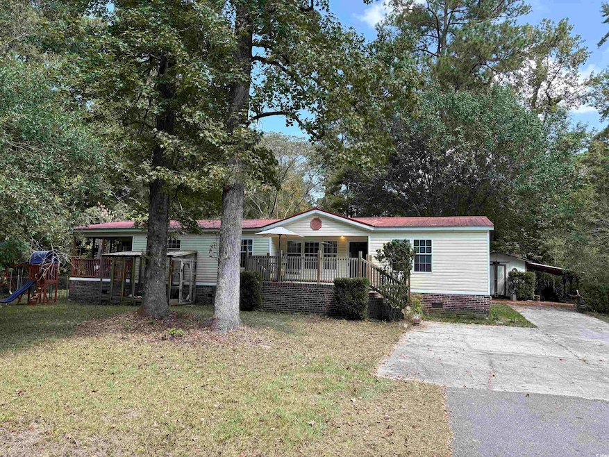 Manufactured / mobile home with a front yard, driveway, crawl space, and a playground