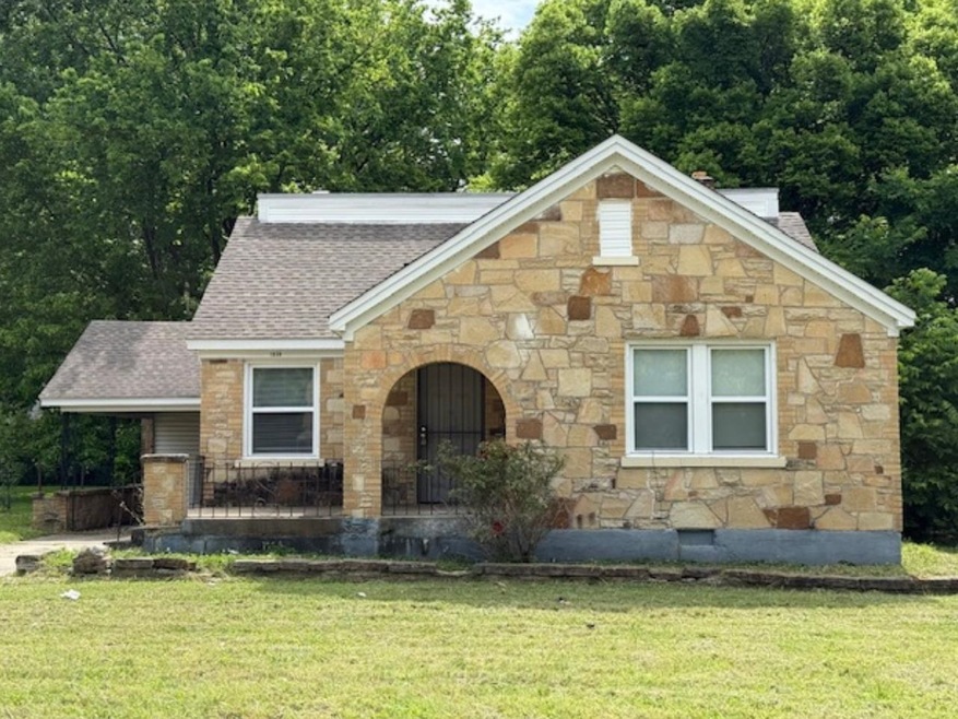 Tudor home with stone front, a front yard, and newer roof