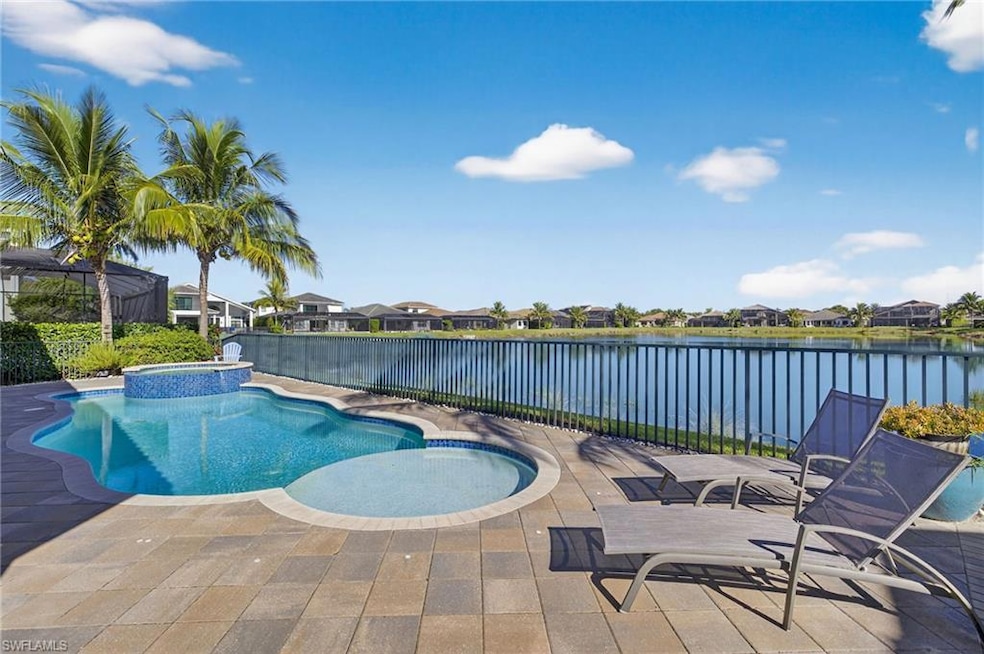 View of pool with a residential view, a patio area, a pool with connected hot tub, and a water view