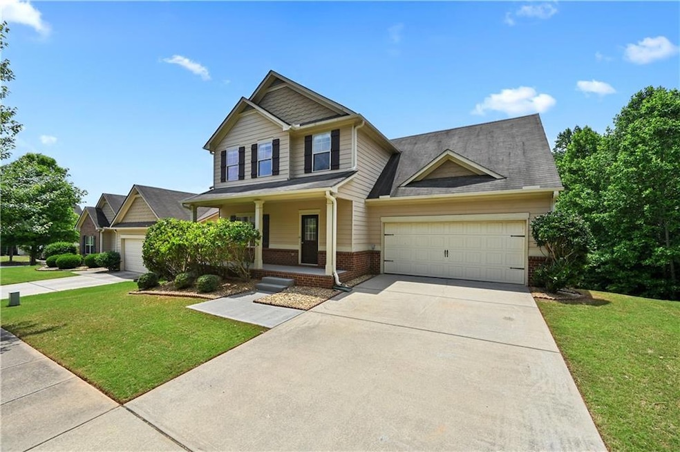 Craftsman-style house with brick siding, an attached garage, driveway, and covered porch