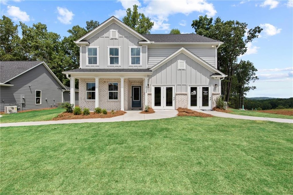 View of front of property with french doors, board and batten siding, and a front yard