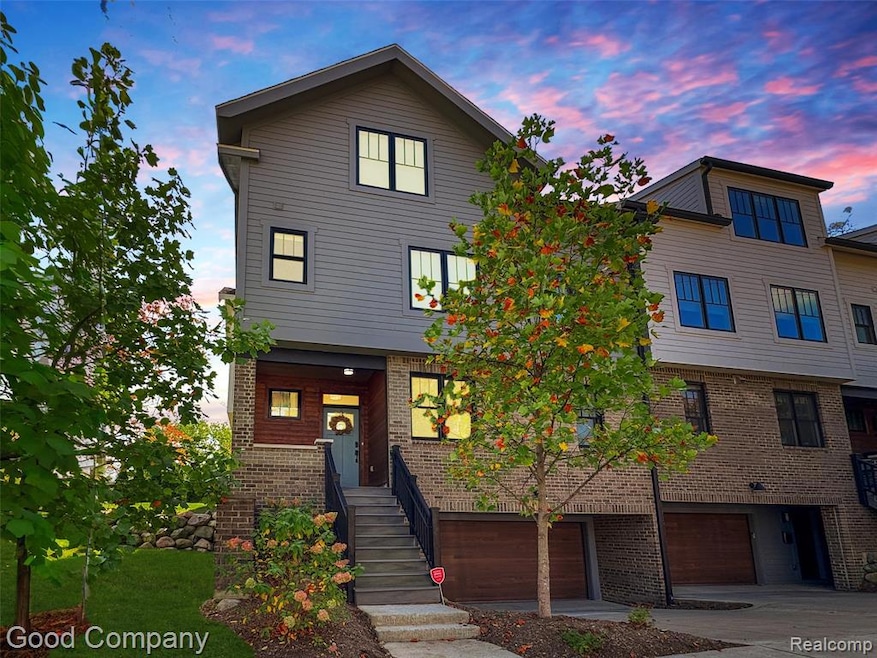 View of front of property with brick siding, concrete driveway, and a garage