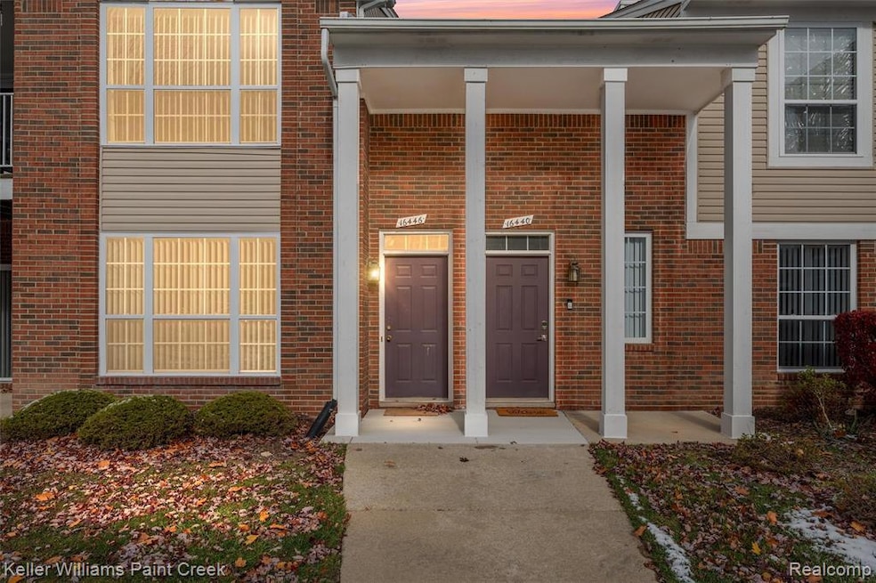 Entrance to property with a porch and brick siding